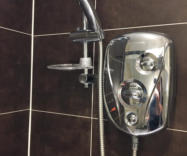 Electric shower installed on black bathroom wall ties - Full Circuit Electrical